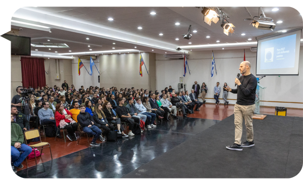 Alejandro Melamed durante una conferencia ante un auditorio amplio.